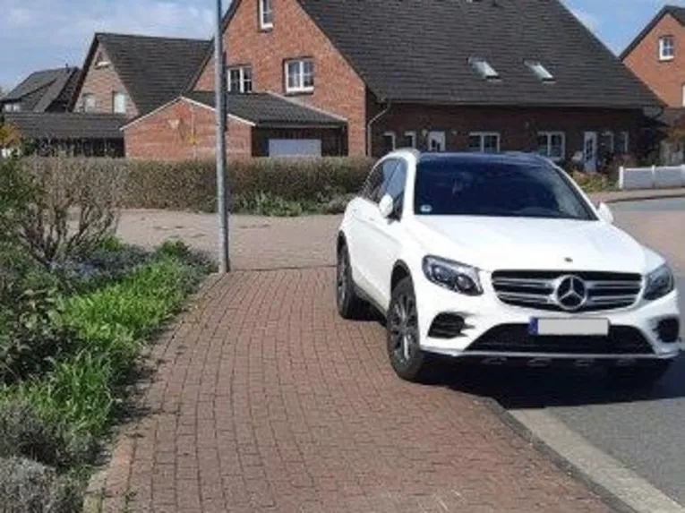Ein geparktes Auto steht auf dem Gehweg